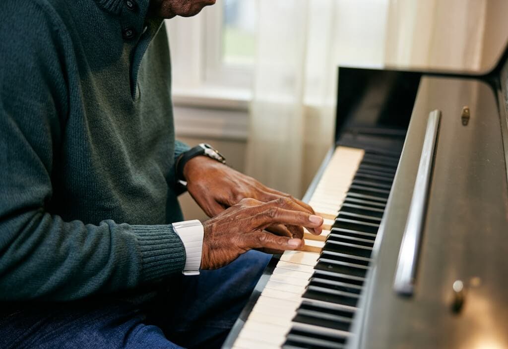 Man playing the piano while wearing his Silvertree Reach