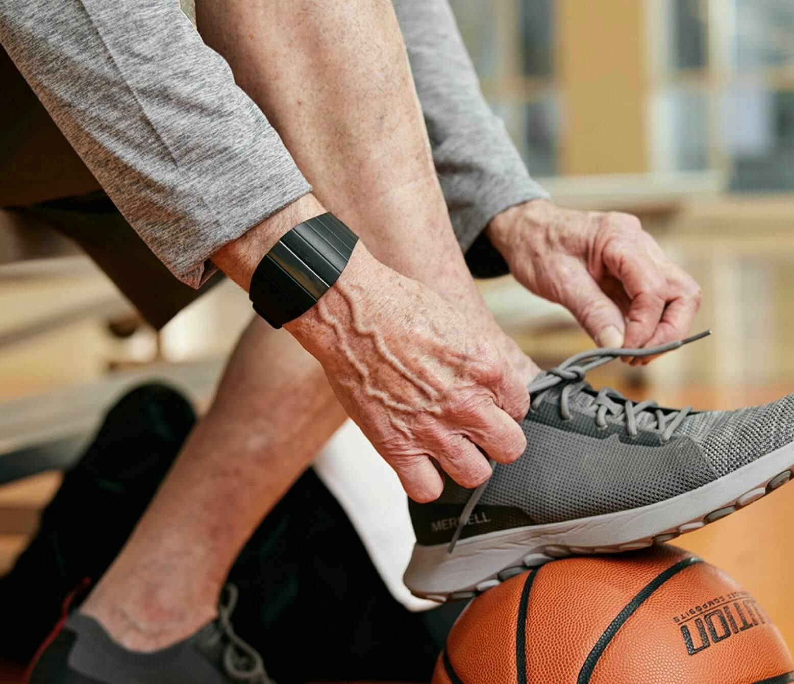 Man tying shoe on basketball